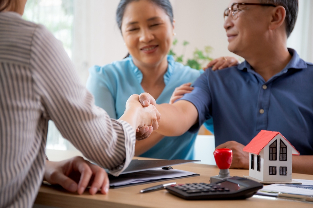 Happy,Couple,Elderly,Handshake,With,Mortgage,Officer,With,Agreement,Approve